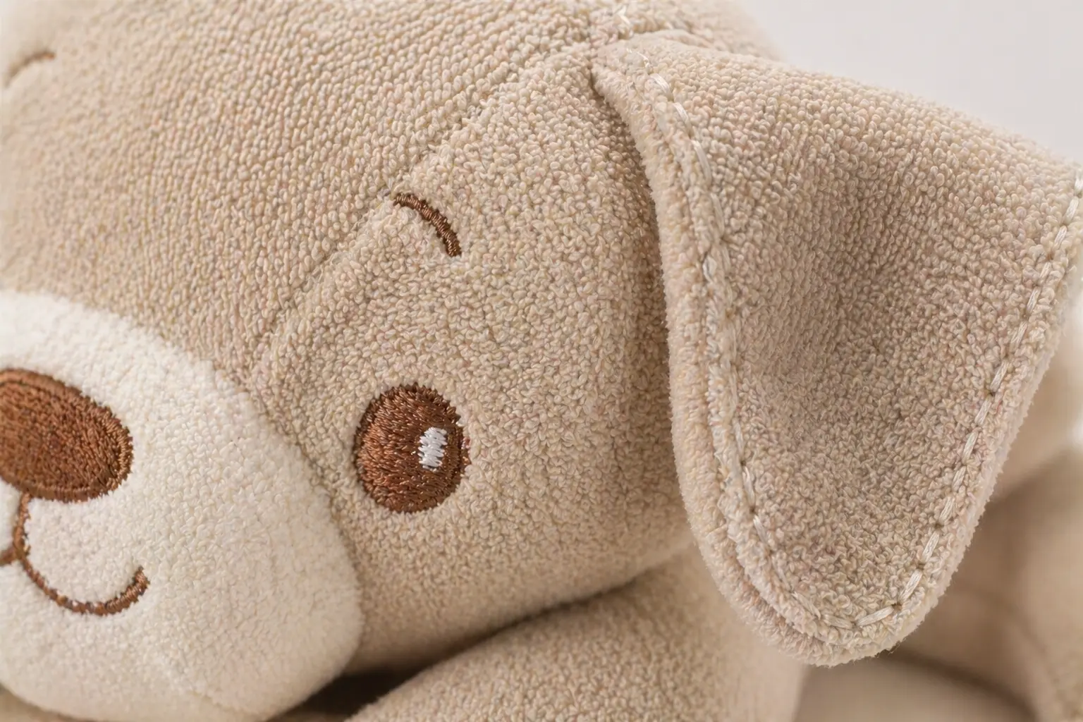 Baby and kids soft goods development scene with comfort items, soft books, baby plush samples, fabric swatches, and quality review materials